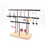 Three-tier black metal earring display stand with natural wood base for jewelry storage