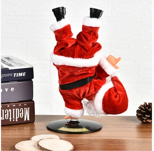 Giocattolo Babbo Natale che balla a testa in giù su una scrivania di legno festiva