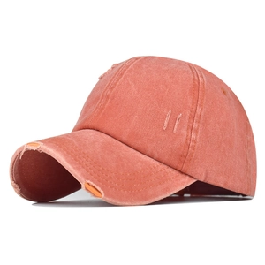 Détail de la casquette en coton lavé corail avec texture usée vintage sur le bord de la visière
