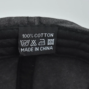 Détail de l'étiquette d'entretien interne de la casquette de baseball en coton lavé 100% coton