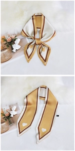 Detail of silk scarf with heart patterns and yellow stripes on a satin finish