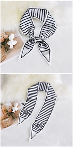 Detail of a black and white striped skinny scarf tied on a handle with elegant props