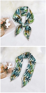 Detail of leopard and palm leaf print skinny silk scarf tied in an elegant knot