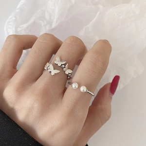 Close-up of S925 silver butterfly ring and pearl open ring worn by a model