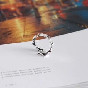 Macro detail of S925 sterling silver hollow heart ring on a vintage magazine page