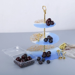 Detail of 3-tier blue resin fruit tray with gold foil accents and branch metal handle