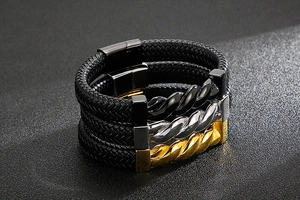 Detailed view of woven leather bracelets with silver, gold, and black steel magnetic clasps