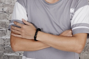Close-up of black braided leather bracelet with stainless steel clasp on male wrist