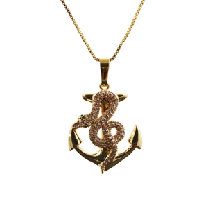 Macro detail of gold snake and anchor pendant necklace with pink and green micro zircons