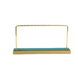 Close-up of gold metal jewelry stand with green microfiber base for earrings and necklaces
