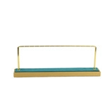 Detail of teal velvet jewelry display stand with golden metal necklace hangers