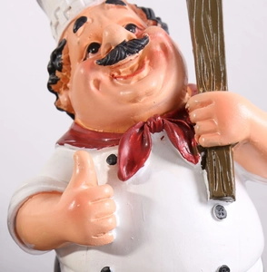 Detailansicht einer Koch-Figur im nordischen Stil mit Daumen hoch und schwarzer Tafel