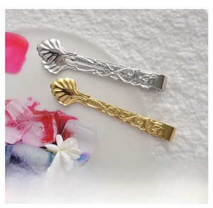 Macro detail of 304 stainless steel sugar tongs with embossed rose and floral head