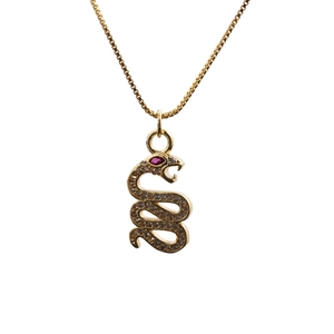 Close-up of golden snake pendant with micro-paved zircons and red gemstone eyes