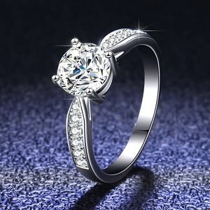 Macro side view of a 1 carat moissanite ring with four-prong setting and pavé silver band