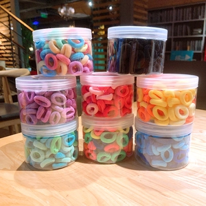 Close-up of colorful seamless elastic hair ties stored in transparent cylindrical jars