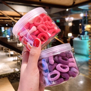 Close-up of colorful high-elasticity hair ties in clear storage jars for girls