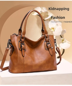 Close-up of a brown vintage tote bag featuring a waxy texture and metal buckles