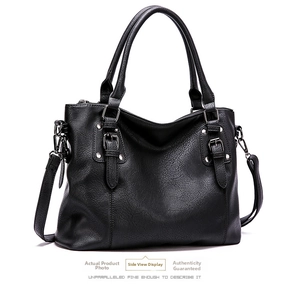 Close-up of black litchi grain leather tote bag featuring metal buckles and detachable strap