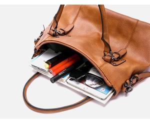 Detail view of brown leather handbag interior showing large capacity for tablet and phone