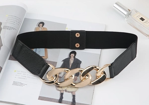 Détail d'une ceinture élastique noire avec boucle chaîne dorée et fermeture à pression
