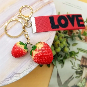 Charming red strawberry keychain with golden metal clasp and red 'LOVE' printed ribbon