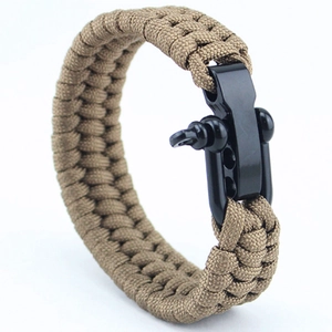 Detail of khaki survival bracelet with a durable black metal shackle on white background