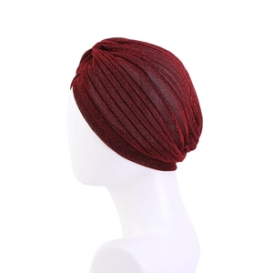 Ethnic burgundy sparkling turban cap for women shown on a white mannequin head display