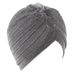 Detailed close-up of silver glitter fabric and top knot on a shimmering turban cap