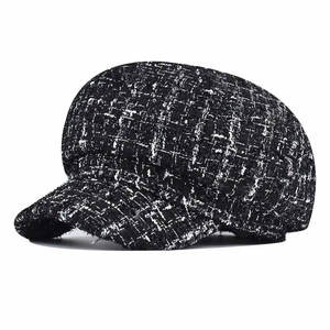 Classic black and white tweed newsboy cap with textured wool finish on white background
