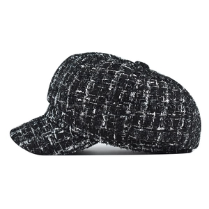 Close-up of black and white tweed newsboy cap showing detailed woven pattern and structure