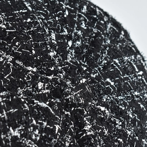 Close-up of black and silver tweed fabric with metallic glitter yarn and rich texture