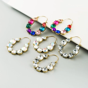 Macro view of horseshoe-shaped gold earrings with colorful rhinestones and crystal detail