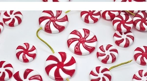 Detailed view of red and white spiral candy beads with gold hanging strings for DIY decor