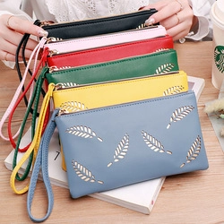 Macro detail of fashionable hollowed leaf design wallets in multiple colors with wrist strap