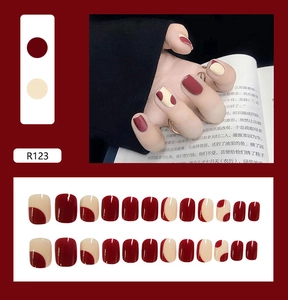 Short square press-on nails in deep burgundy and cream white wavy color block design