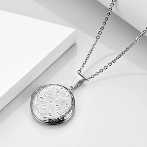 Detailed macro of vintage silver floral embossed round locket with delicate metal carvings