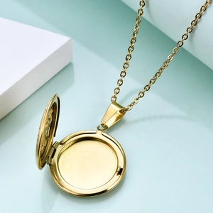 Detailed view of an open golden round locket pendant showing the internal photo frames