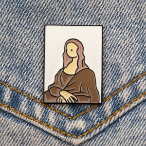 Gros plan d'une épinglette en émail Mona Lisa sur une poche en jean bleu avec détails