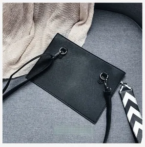 Detail of crossbody bag with interchangeable black leather and woven geometric straps