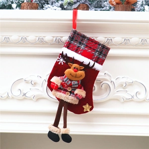 Detail eines roten Weihnachtsstrumpfs mit kariertem Rentier und hängenden Beinen