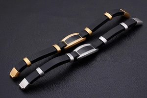 Macro detail of men's black leather bracelets with gold and silver cubic zirconia clasps