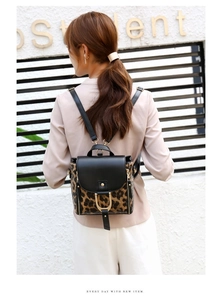 Detail of leopard print backpack with black leather flap and gold horseshoe buckle