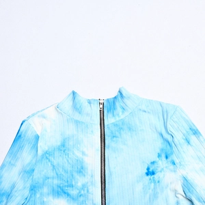 Détail de la combinaison côtelée tie-dye bleu et blanc avec zip noir et col montant