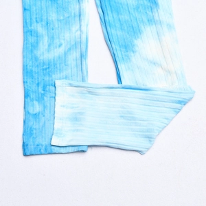 Gros plan sur la texture en maille côtelée tie-dye bleu d'une combinaison ajustée