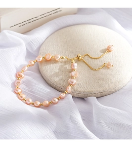 Macro detail of natural baroque pearls with 14K gold plated beads and adjustable chain