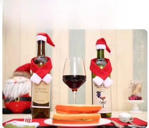 Detailed close-up of a festive Christmas wine bottle set with a mini red hat and scarf