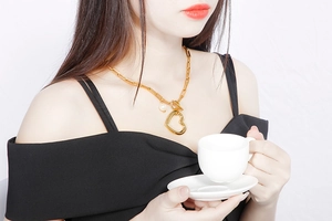 Pendentif cœur doré sur chaîne trombone porté par un mannequin en haut noir