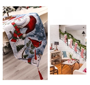 Detail of Christmas jacquard table runner with snowman patterns and red tassel edges