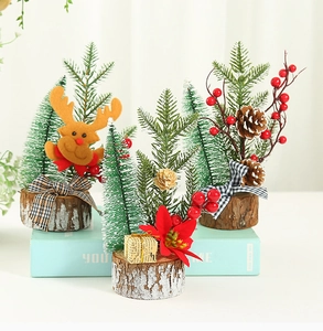 Miniature Christmas trees on wooden bases with pine cones, red berries and felt reindeer
